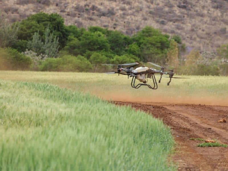 Drone performing LiDAR mapping over a large rural property with open fields, rolling terrain, wooded areas, and 3D elevation visualization.